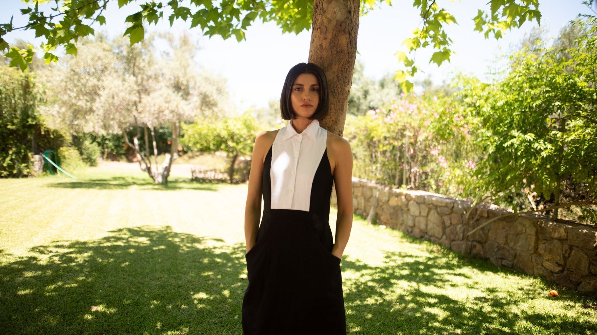Black Tuxedo linen dress lifestyle photo under a tree, showing how linen fabric holds its shape and fit